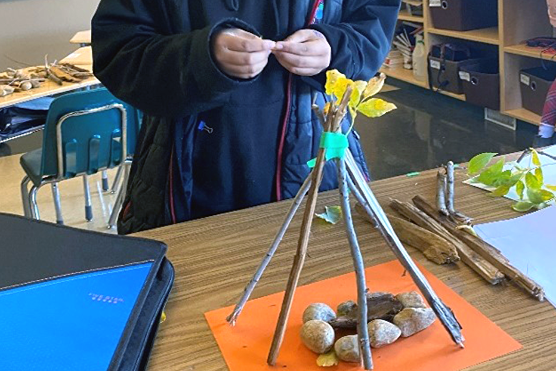 Youth building a teepee